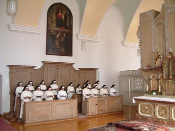 Ordensschwestern im Chorgestühl einer Kirche beim Gebet